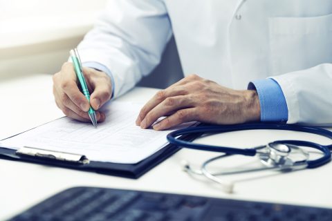 doctor working in office writing documents